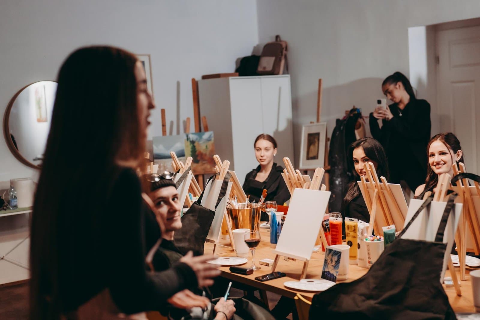 Finished canvas and a glass of wine on the studio table